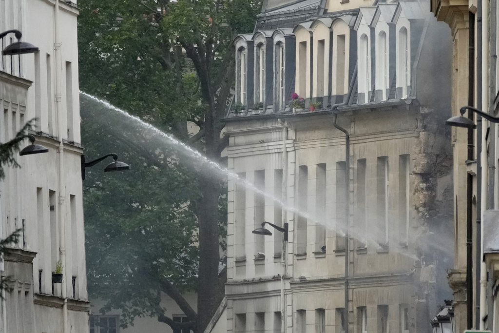 Firemen use a water canon as they fight a blaze Wednesday, June 21, 2023 in Paris. Firefighters fought a blaze on Paris' Left Bank that is sent smoke soaring over the domed Pantheon monument and prompted evacuation of buildings in the neighborhood, police said. Local media cited witnesses describing a large explosion preceding the fire, and saying that part of a building collapsed.