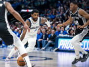 FILE - Dallas Mavericks guard Kyrie Irving (2) drives past San Antonio Spurs guard Malaki Branham (22) in the second half of an NBA basketball game Feb. 23, 2023, in Dallas. Irving agreed to stay with the Mavericks on a three-year, $126 million deal when free agency opened Friday, June 30, 2023. (AP Photo/Emil T.