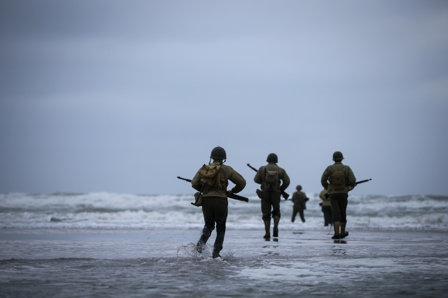 World War II reenactors walk on Omaha Beach in Saint-Laurent-sur-Mer, Normandy, France, Tuesday, June 6, 2023. The D-Day invasion that helped change the course of World War II was unprecedented in scale and audacity. Nearly 160,000 Allied troops landed on the shores of Normandy at dawn on June 6, 1944.