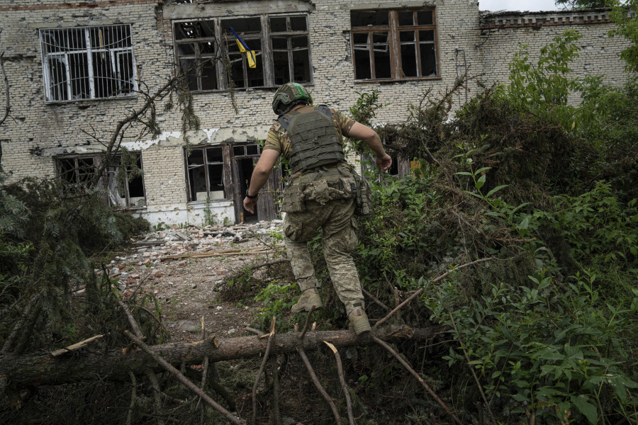 A Ukrainian serviceman of the 68th Oleksa Dovbush hunting brigade runs to his position in the recently retaken village of Blahodatne, Ukraine, Saturday, June 17, 2023.