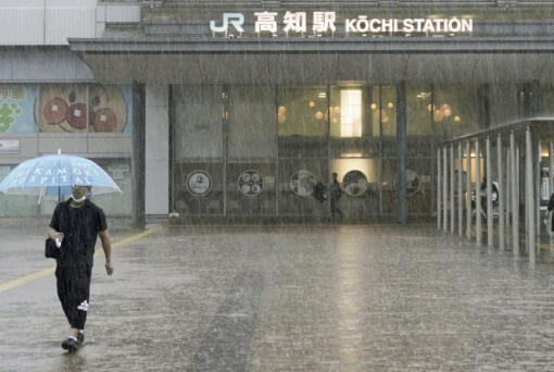 A person walks in a strong rain in Kochi, southern Japan Friday, June 2, 2023. A weakened Tropical Storm Mawar brought heavy rains to Japan's main southern islands Friday after passing the Okinawan archipelago and causing injuries to several people.