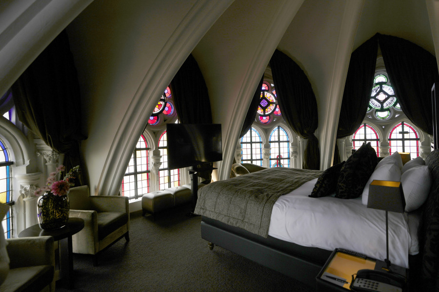 Sunlight filters in through stained glass windows in a guest room June 19 at the Martin's Patershof hotel in the center of Mechelen, Belgium.