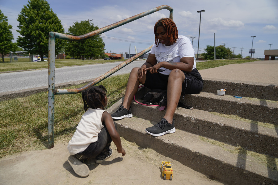 Toriana Hill sits outside a Red Cross shelter with her son Nassir Gladney, 3, and puppy Luna, Wednesday, May 31, 2023, in Davenport, Iowa. Hill and her son escaped from the sixth floor after their apartment building partially collapsed Sunday afternoon. Five residents of the same building remained unaccounted for Wednesday, and authorities feared at least two of them might be stuck inside rubble that was too dangerous to search.