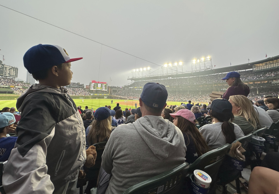 Fans watch a baseball game between the Philadelphia Phillies and Chicago Cubs as smoke from Canada's ongoing wildfires shrouds Wrigley Field in a haze, in Chicago, Tuesday, June 27, 2023.