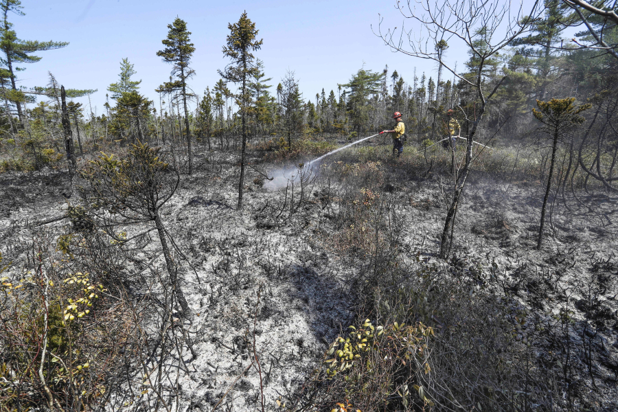 Department of Natural Resources and Renewables firefighters Walter Scott, left, and Zac Simpson work on a fire in Shelburne County, Nova Scotia onThursday, June 1, 2023.