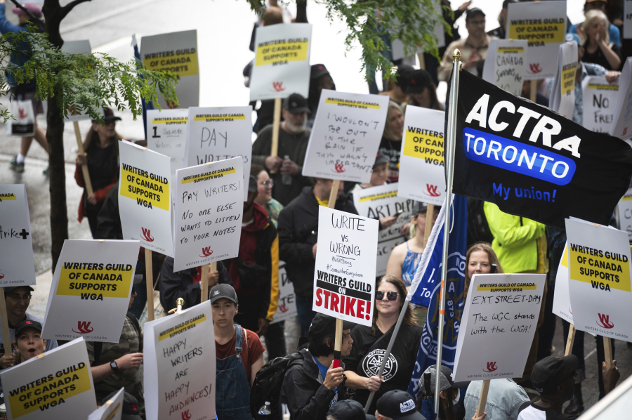 Members of the Writers Guild of Canada and their supporters, gather outside the office building for both Amazon and Apple, for a rally in support of striking Writers Guild of America members, Wednesday, June 14, 2023.