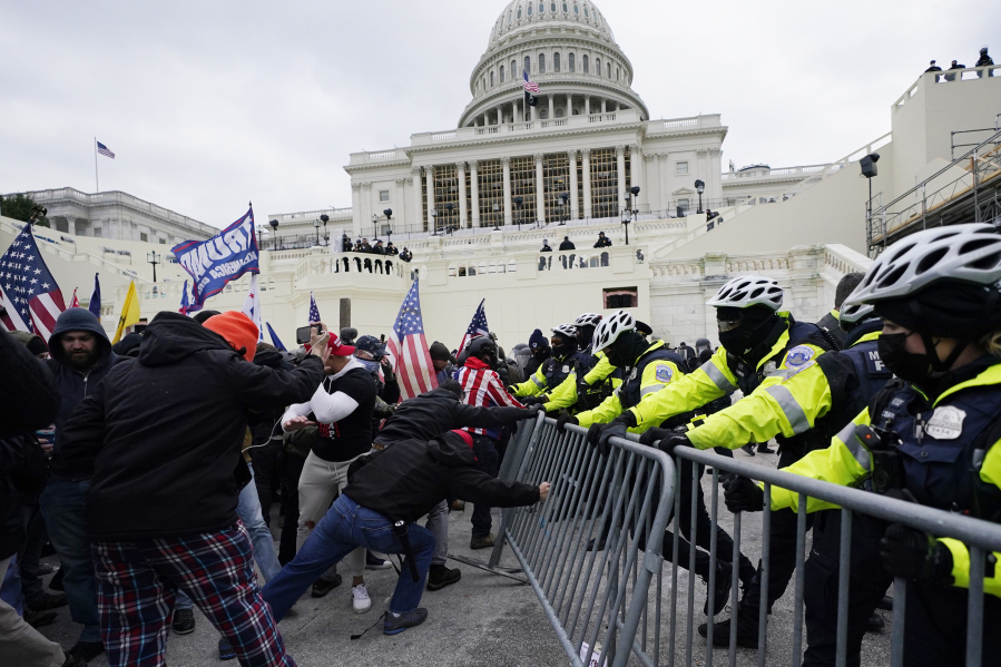 FILE - Rioters supporting President Donald Trump try to break through a police barrier at the Capitol in Washington, on Jan.
