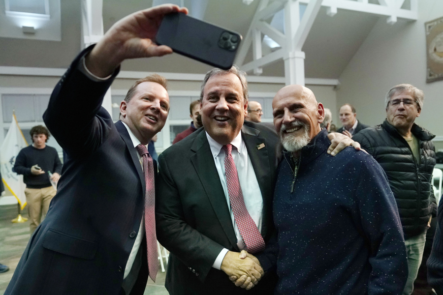 Former New Jersey Gov. Chris Christie, center, poses for a selfie after a town hall style meeting at New England College, April 20, 2023, in Henniker, N.H. Christie is set to launch his campaign for the White House at a town hall in New Hampshire on June 6.