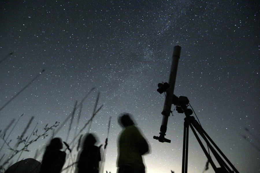 FILE - People look up to the sky at an observatory near the village of Avren east of the Bulgarian capital Sofia, Wednesday, Aug. 12, 2009. There's another chance to see five planets lined up in the sky, weather permitting. Saturn, Neptune, Jupiter, Uranus and Mercury will appear together before sunrise on Saturday., June 17, 2023. Jupiter and Saturn will be bright in the sky and easiest to see. Mercury will be the lowest to the horizon and harder to spot. And you'll need to break out binoculars or a telescope to find Neptune and Uranus.