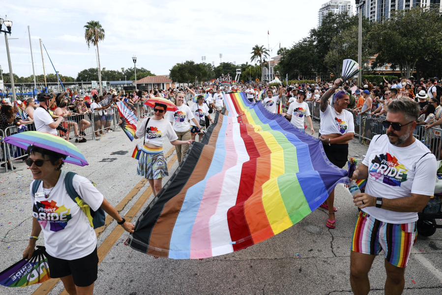 A long Pride flag is carried during the St. Pete Pride Parade along Bayshore Drive on Saturday, June 24, 2023, in St. Petersburg, Fla.