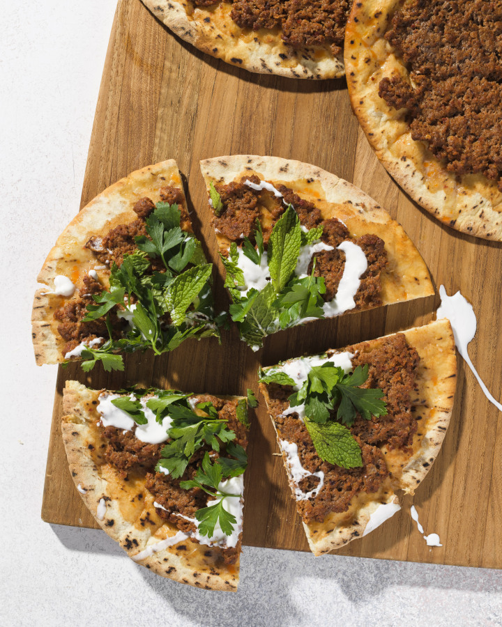 This image released by Milk Street shows a recipe for lahmajoun, a flatbread topped with spiced ground lamb, tomatoes and bell pepper.