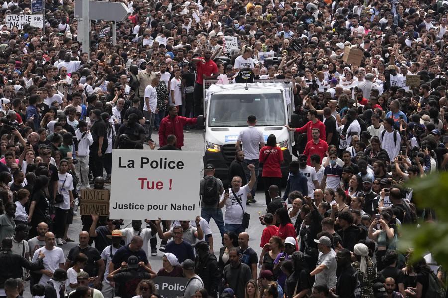 Demonstrators carry a poster reading "Police kills, Justice for Nahel" as Nahel' s mother, center on truck, gestures during a march for her son, Thursday, June 29, 2023 in Nanterre, outside Paris. The killing of 17-year-old Nahel during a traffic check Tuesday, captured on video, shocked the country and stirred up long-simmering tensions between young people and police in housing projects and other disadvantaged neighborhoods around France.