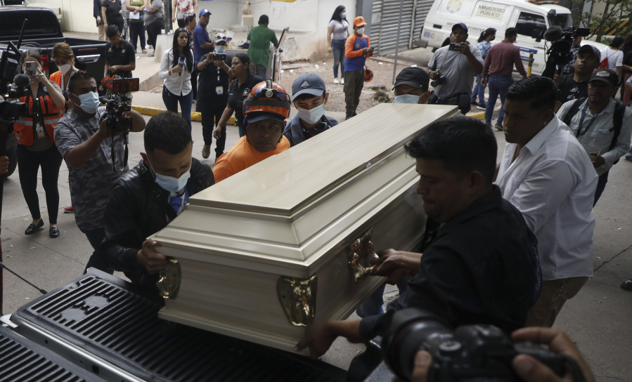 People place a coffin containing the remains of a female inmate into a hearse in Tegucigalpa, Honduras, Wednesday, June 21, 2023. A riot on Tuesday at a women's prison northwest of the Honduran capital left at least 46 inmates dead, many of them burned, shot or stabbed to death, a Honduran police official said.