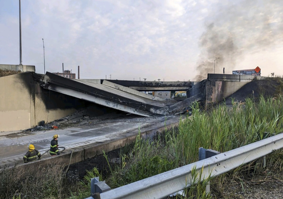 This image provided by the Philadelphia Fire Department shows firefighters standing near the collapsed part of I-95 in Philadelphia, Sunday, June 11, 2023. The elevated section of Interstate 95 has collapsed early Sunday after a vehicle caught fire, closing the main north-south highway on the East Coast and threatening to upend travel in parts of the densely populated Northeast.