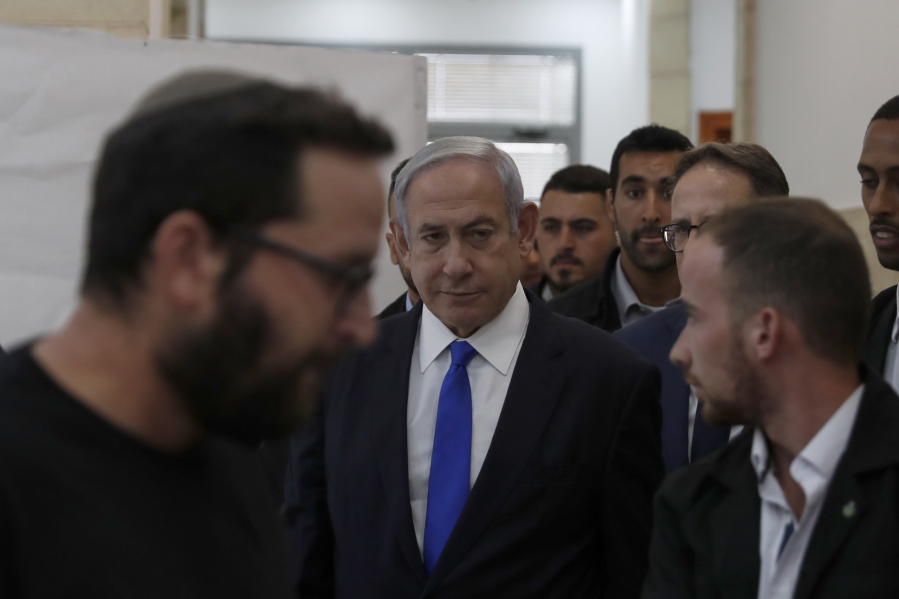 Israeli Prime Minister Benjamin Netanyahu, center, arrives at the District Court in Jerusalem, Israel, Sunday, June 25, 2023. Hollywood producer Arnon Milchan was testifying Sunday at Netanyahu's corruption trial to answer questions about an alleged "supply line" of champagne and cigars funneled to the Israeli leader and his wife said to have been in exchange for help with Milchan's personal and business needs. Milchan appeared by videoconference from the English city of Brighton.