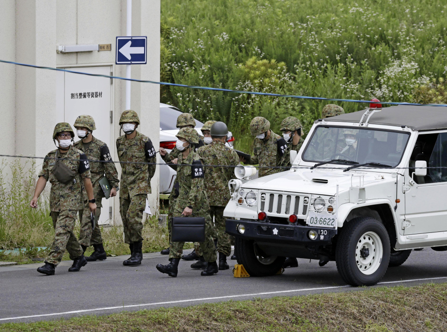 Members of Japan's Self Defense Force gather near a firing range on a Japanese army base following a deadly shooting in Gifu, central Japan, Wednesday, June 14, 2023. An army trainee was arrested Wednesday after allegedly shooting three fellow soldiers at the army base, officials said.