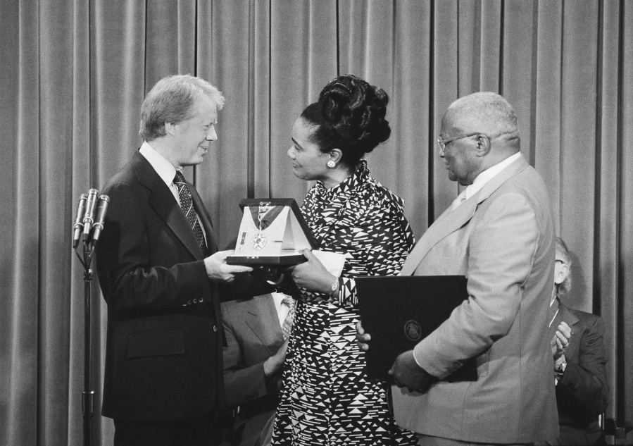 FILE - President Jimmy Carter, left, presents the Medal of Freedom Award to Coretta King, wife of the late Martin Luther King Jr., during a ceremony at the White House in Washington on Monday, July 13, 1977. Referring to the late Dr. King, the inscription on the award states that King "was the conscience of his generation." At right is Martin Luther King, Sr., father of the slain civil rights leader.