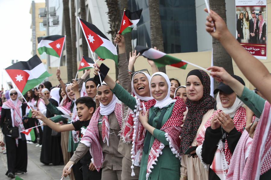 Jordanians wave the national flags in anticipation of the royal motorcade in Amman, Jordan on Thursday, June 1, 2023, just ahead of Crown Prince Hassan and saudiSaudi architect Rajwa Alseif's wedding.