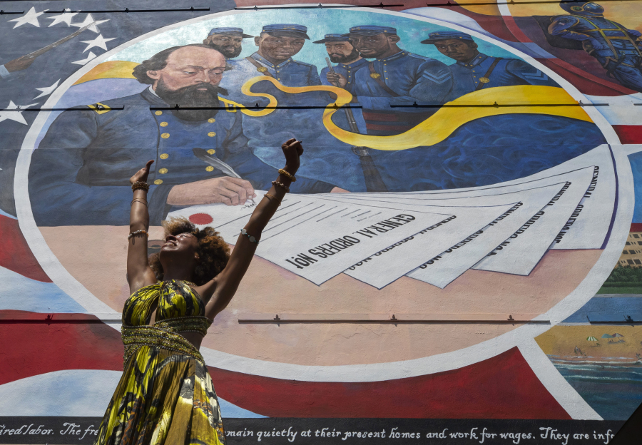 FILE - Dancer Prescylia Mae, of Houston, performs during a dedication ceremony for the massive mural "Absolute Equality" in downtown Galveston, Texas, on June 19, 2021. Communities all over the country will be marking Juneteenth, the day that enslaved Black Americans learned they were free. For generations, the end of one of the darkest chapters in U.S. history has been recognized with joy in the form of parades, street festivals, musical performances or cookouts. Yet, the U.S. government was slow to embrace the occasion.