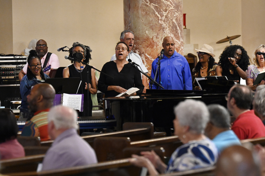 The Gesu Choir, standing, is cheered on by the congregation as they sing during Mass, Sunday, June 18, 2023, at Gesu Catholic Church in Detroit.