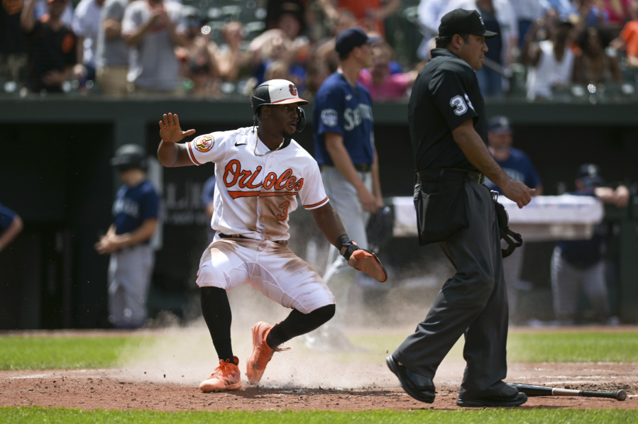 Baltimore Orioles' Jorge Mateo reacts after sliding to score on catcher Anthony Bemboom's double during the fifth inning of a baseball game against the Seattle Mariners, Sunday, June 25, 2023, in Baltimore.