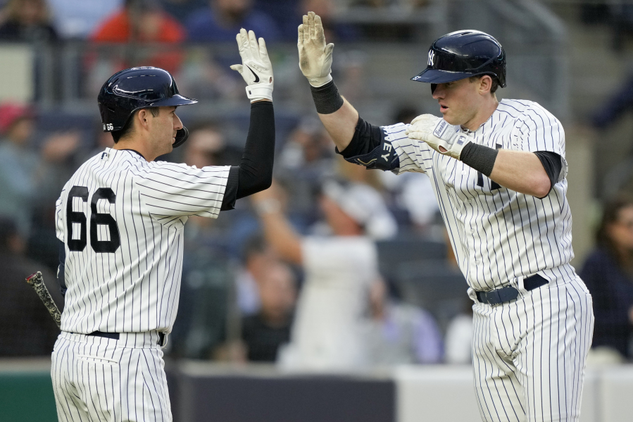 New York Yankees' Billy McKinney, right, celebrates with Kyle Higashioka (66) after hitting a solo home run off Seattle Mariners starting pitcher Luis Castillo in the fourth inning of a baseball game, Wednesday, June 21, 2023, in New York.