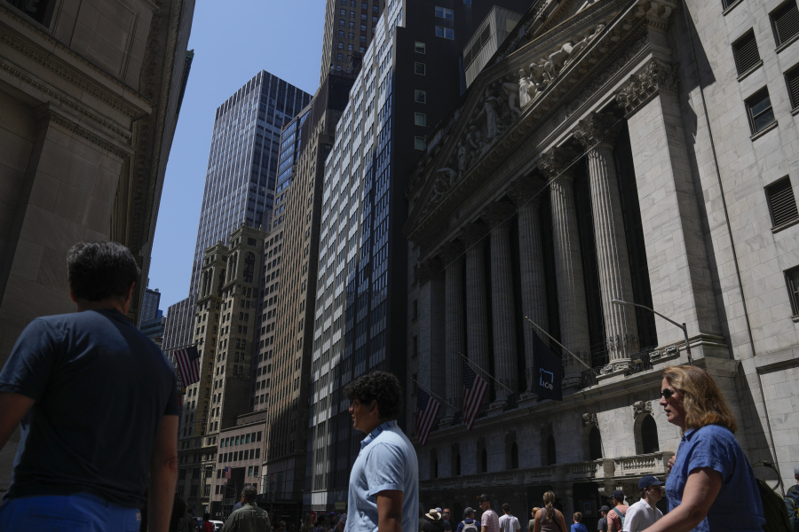 FILE - People walk around the front of the New York Stock Exchange in New York, June 2, 2023. Wall Street is ticking higher ahead of a big week for central banks and interest rates around the world. The S&P 500 was 0.2% higher early Monday, June 12.