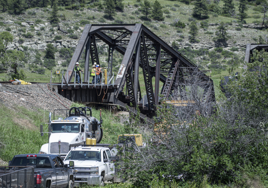 Crews work the site of a railroad bridge that collapsed the day before on the Yellowstone River near Reed Point, Sunday, June 25, 2023, in Columbus, Mont.