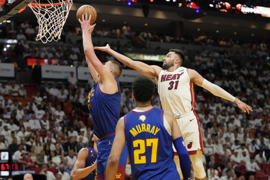 Denver Nuggets center Nikola Jokic (15) drives to the basket as Miami Heat guard Max Strus (31) attempts to defend during the first half of Game 3 of the NBA Finals basketball game, Wednesday, June 7, 2023, in Miami.