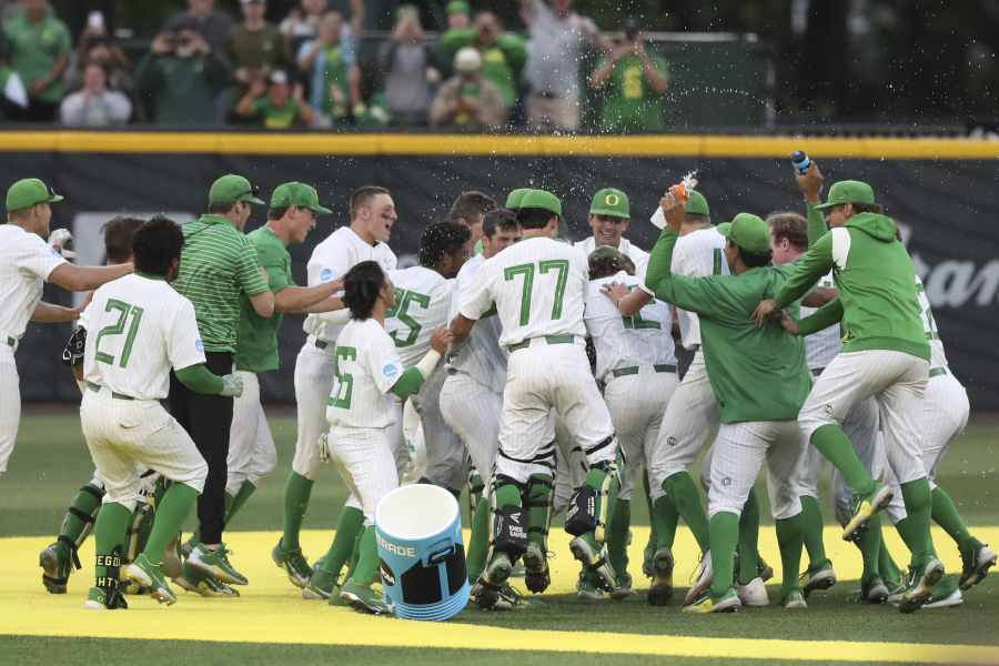 Oregon players celebrate after their win over Oral Roberts in an NCAA college baseball tournament super regional game Friday, June 9, 2023, in Eugene, Ore.