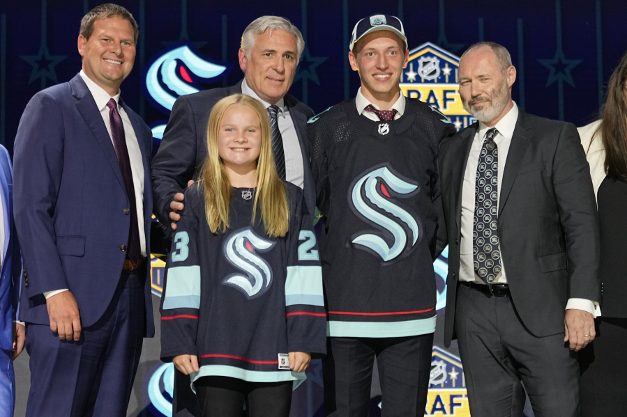Eduard Sale, second from right, poses with Seattle Kraken officials after being picked 20th overall by the team during the first round of the NHL draft on Wednesday at Nashville, Tenn.