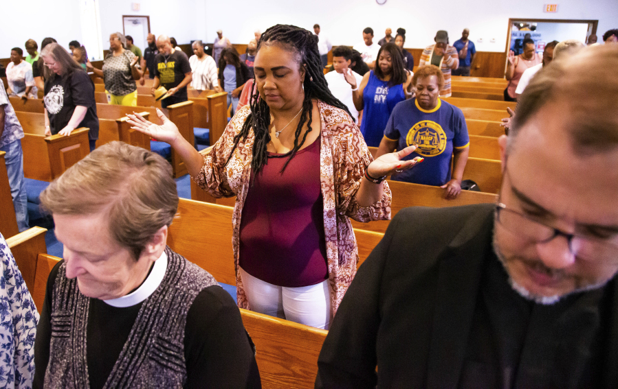 Attendees pray during a press conference with attorney Ben Crump regarding the shooting of Ajike Owens,, Wednesday afternoon, June 7, 2023, at the New St. John Missionary Baptist Church in Ocala, Fla. Susan Louise Lorincz, 58, who is accused of fatally shooting Owens last week in the violent culmination of what the sheriff described as a 2 and a half year feud was arrested Tuesday, June 6, the Marion County Sheriff's Office said.