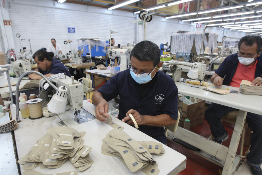 File - A man works in a shoe maquiladora or factory, in Leon, Mexico, Monday, Feb. 7, 2023. While the USMCA's broad impact has been slight, it has nevertheless been aiding workers on the ground and the main beneficiaries have been in Mexico.