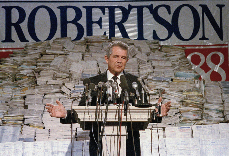 FILE - Pat Robertson, stands in front of stacks of signatures as he announced his intentions to collect a total of 7 million signatures during a news conference on Sept. 15, 1987 in Chesapeake, Va. Robertson, a religious broadcaster who turned a tiny Virginia station into the global Christian Broadcasting Network, tried a run for president and helped make religion central to Republican Party politics in America through his Christian Coalition, has died. He was 93. Robertson's death Thursday, June 8, 2023 was announced by his broadcasting network.