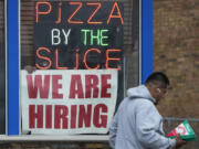 FILE - A hiring sign is displayed at a restaurant in Prospect Heights, Ill., on April 4, 2023. The hot jobs market has been defying a weakening economy and confounding the Federal Reserve for months, but now shows signs of cooling. The latest set of employment data from the government shows that job openings fell in March to their lowest level since April 2021. Layoffs rose to 1.8 million, their highest level since December 2020. (AP Photo/Nam Y.