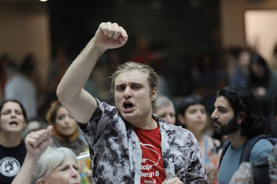 A protester chants by the Atlanta City Hall atrium as they line up to enter the chamber. The city council is voting on a funding package for the proposed public safety training center on Monday, June 5, 2023.