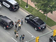 People scatter from a shooting scene as police arrive Tuesday, June 6, 2023, in Richmond, Va. Authorities in Richmond, Virginia, say seven people were shot following a high school graduation ceremony held at a downtown theater near Virginia Commonwealth University. Interim Police Chief Rick Edwards said at a news conference that two suspects were taken into custody after Tuesday's shooting.