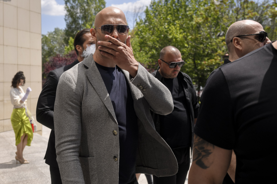 Andrew Tate gestures as he leaves the Bucharest Tribunal, along with his brother Tristan, right, after the first hearing in their trial, meant to establish if they will remain under house arrest, in Bucharest, Romania, Wednesday, June 21, 2023. Romanian prosecutors charged on Tuesday, June 20, 2023, the Tate brothers and two other suspects with human trafficking, rape and organizing a criminal group for the sexual exploitation of women.