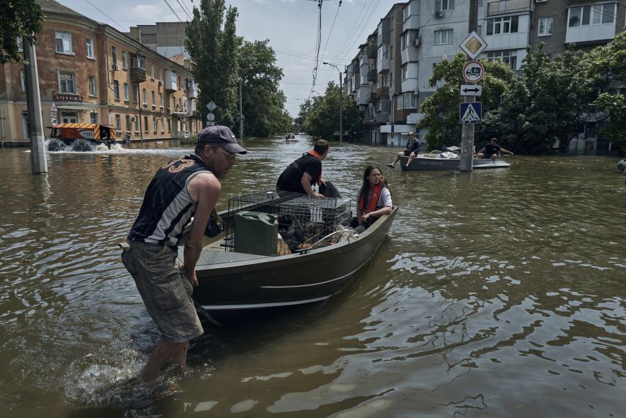 People with pets are evacuated on a boat from a flooded neighbourhood in Kherson, Ukraine, Thursday, June 8, 2023. Floodwaters from a collapsed dam kept rising in southern Ukraine on Thursday, forcing hundreds of people to flee their homes in a major emergency operation that brought a dramatic new dimension to the war with Russia, now in its 16th month.