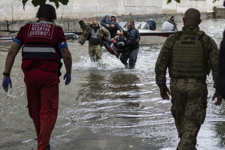 Emergency teams help rush to safety injured civilian evacuees who had came under fire from Russian forces while trying to flee by boat from the Russian-occupied east bank of a flooded Dnieper River to Ukrainian-held Kherson, on the western bank in Kherson, Ukraine on Sunday, June 11, 2023.