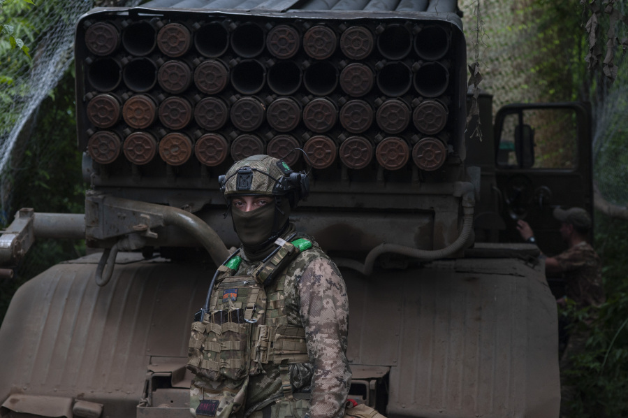A Ukrainian soldier stands next to an MSLR BM-21 "Grad" at the frontline near Bakhmut in Donetsk region, Ukraine, Wednesday, June 21, 2023.