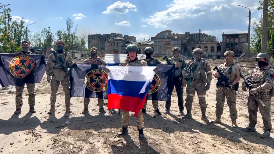 FILE - In this image taken from video and released by the press service of Yevgeny Prigozhin, head of the Wagner private military contractor, on Saturday, May 20, 2023, he speaks while holding a Russian flag in front of his forces in Bakhmut, Ukraine. Some convicts recruited by  Wagner to fight in Ukraine are coming home to Russia and committing new crimes. That has raised fears in communities where the now-freed convicts are returning, and reports of killings, robberies and sexual assaults by some of them are emerging in Russian media.