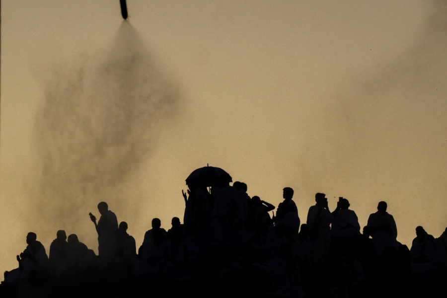 Water mist is sprayed on Muslim pilgrims as they pray on the rocky hill known as the Mountain of Mercy, on the Plain of Arafat, during the annual Hajj pilgrimage, near the holy city of Mecca, Saudi Arabia, Tuesday, June 27, 2023. Around two million pilgrims are converging on Saudi Arabia's holy city of Mecca for the largest Hajj since the coronavirus pandemic severely curtailed access to one of Islam's five pillars.