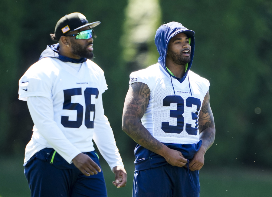 Seattle Seahawks linebacker Jordyn Brooks (56) and safety Jamal Adams (33) talk during NFL football practice, Tuesday, June 6, 2023, at the team's facilities in Renton, Wash.