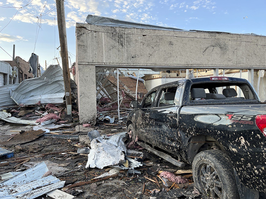 Buildings and a vehicle bear damage from a tornado in Perryton, Texas, Thursday, June 15, 2023.