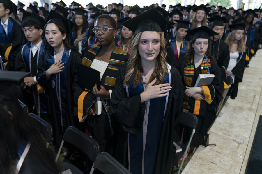 File - Students recite the national anthem during a commencement ceremony for the Georgetown Class of 2022 at the Walsh School of Foreign Service in Washington, Saturday, May 21, 2022. The Supreme Court is expected to announce major decisions Friday on President Joe Biden's student loan forgiveness program and a case that impacts gay rights.
