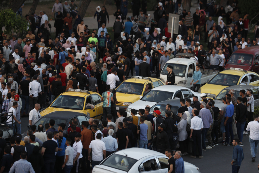 FILE - Dozens of Syrians wait at the President's Bridge in Damascus, Syria, for relatives they hope would be among those released from prison on May 3, 2022, on the second day of the Muslim Fitr holiday. The U.N. General Assembly approved Thursday, June 29, 2023, to form an independent international institution to search for the missing in Syria in both government and opposition-held areas.
