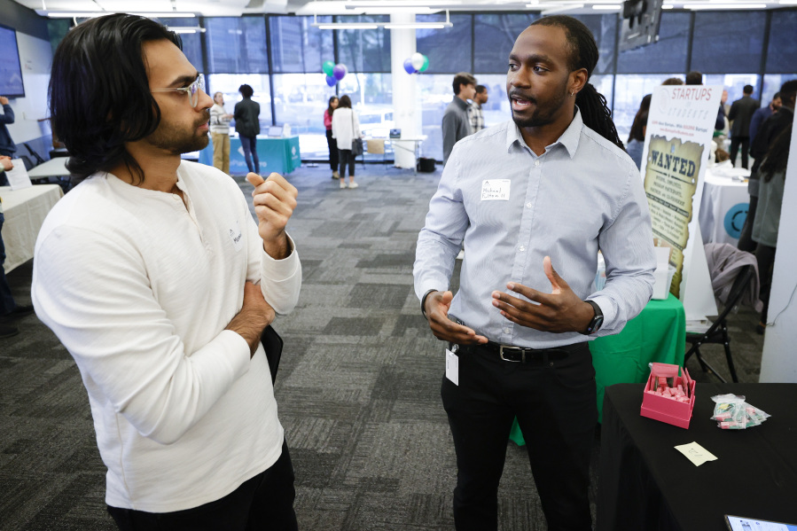 Muhammad Mallick, of Atlanta, left, speaks with Michael Fulton, right, during the Startup Student Connection job fair, Wednesday, March 29, 2023, in Atlanta. Fulton is the CEO of Bizinc, a social media company based in Atlanta.