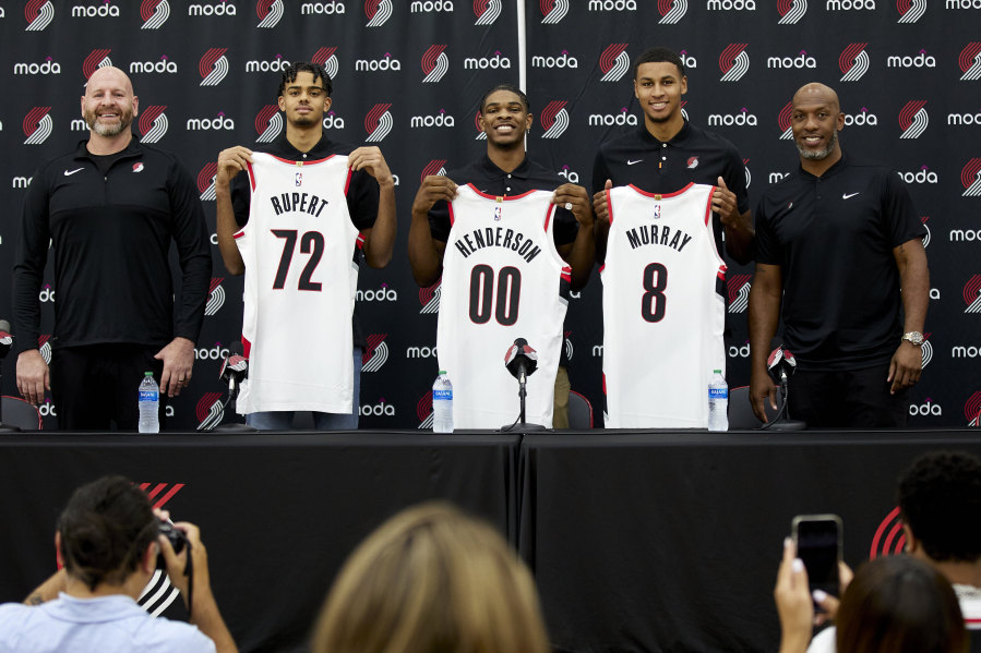 Portland Trail Blazers general manager Joe Cronin, left, and head coach Chauncey Billups, right, stand with draft pics, Rayan Rupert (72), Scoot Henderson (00), and Kris Murray (8) while they hold up their new jerseys during an NBA basketball news conference in Portland, Ore., Saturday, June 24, 2023.