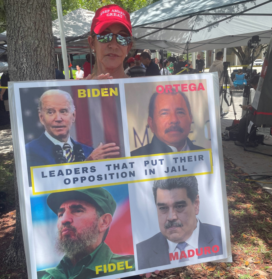Madelin Munilla, 67, who came to Miami as a child when her parents fled Fidel Castro's Cuba, holds up a sign comparing President Joe Biden to Castro and other Latin American leaders at a rally outside the Wilkie D. Ferguson Jr. U.S. Courthouse, Tuesday, June 13, 2023, in Miami.